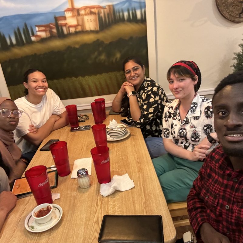 A group of international students sharing a meal around a table